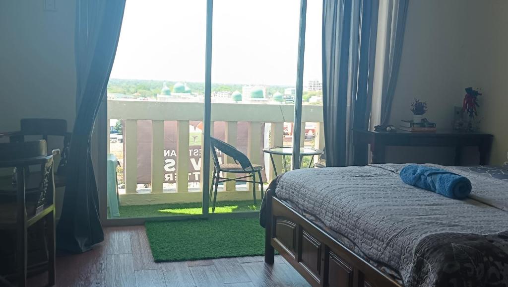 Schlafzimmer mit einem Bett und Blick auf einen Balkon in der Unterkunft Studio Apartment KTC KB in Kota Bharu