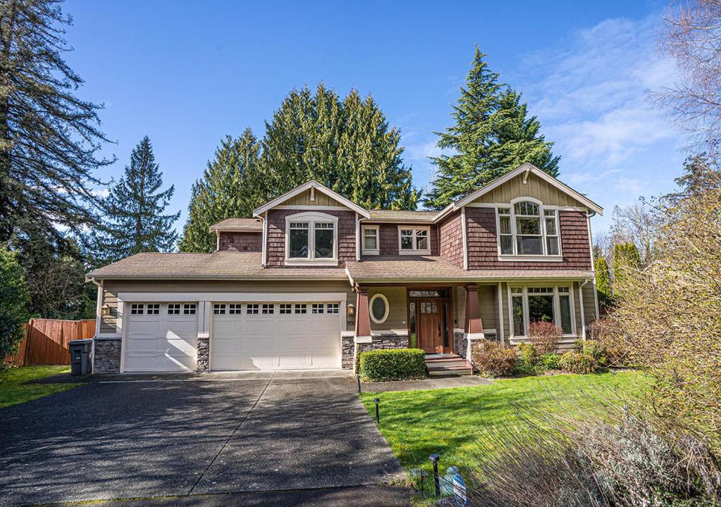 a house with a car garage in a yard at Kirkland's Expansive Custom-Built Family Haven Near Juanita in Kirkland
