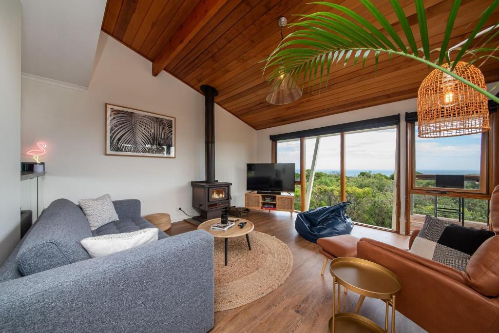 sala de estar con sofá y TV en TJ's Tree House with Ocean Views, en Cape Schanck