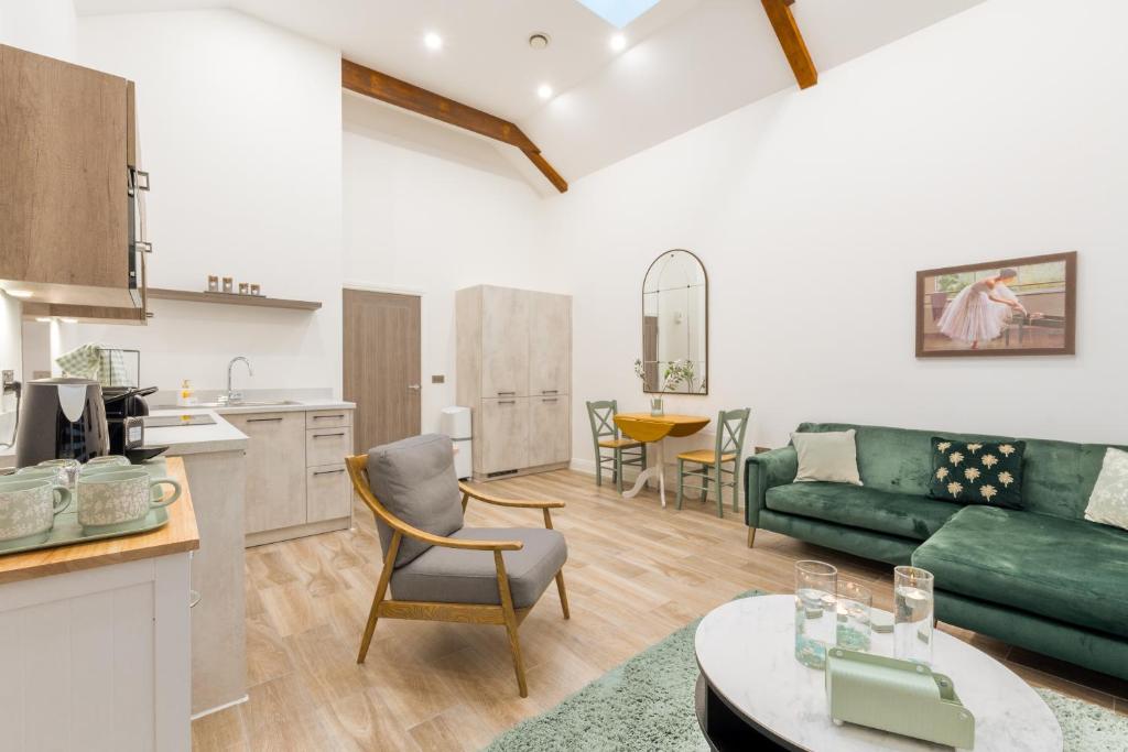 a living room with a green couch and a kitchen at Deansgate Luxury Apartments in Manchester
