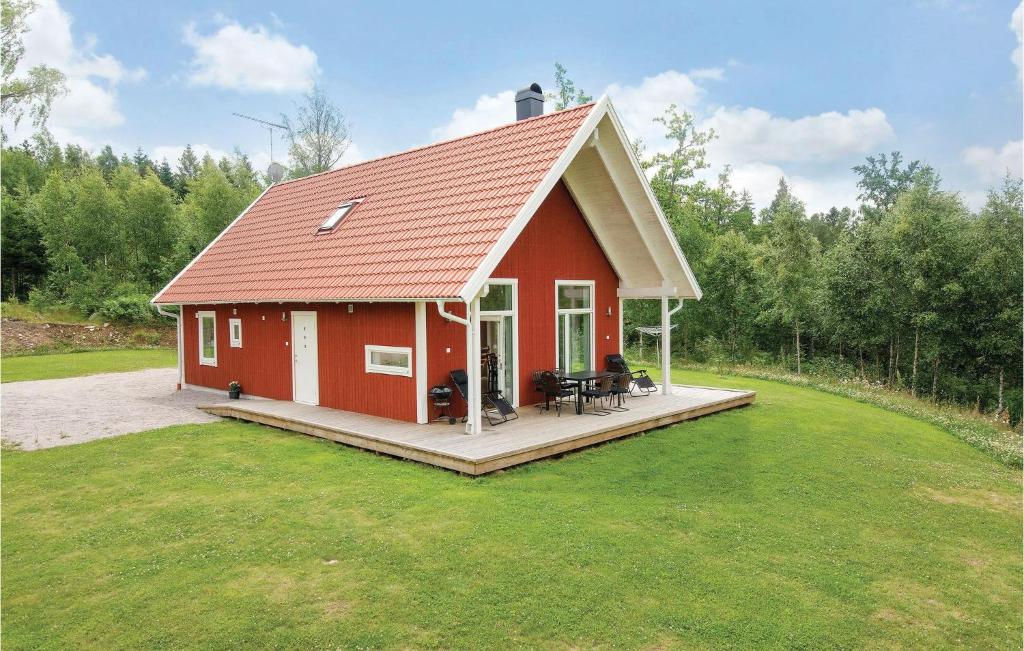 una casa roja con una terraza en el césped en Pet Friendly Home In Holmsj With Kitchen en Holmsjö