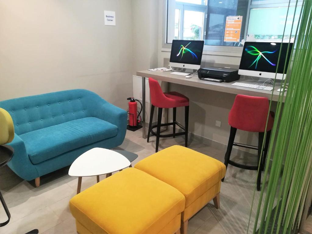 a living room with a couch and a desk with a computer at Holiday Inn Express Amiens, an IHG Hotel in Amiens