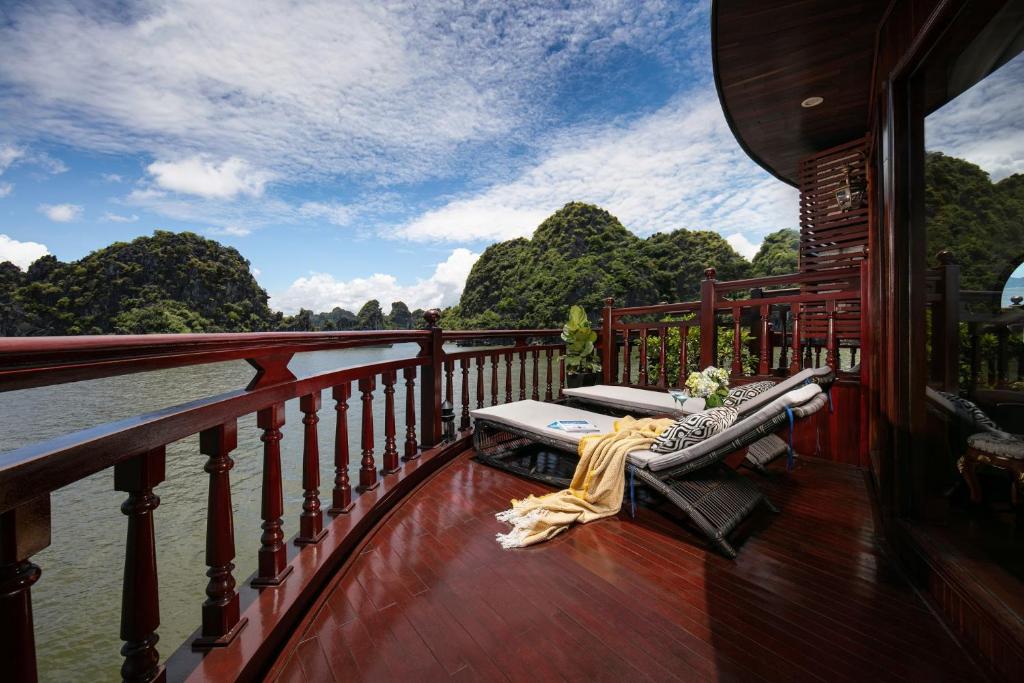 a balcony on a boat with a view of a river at Emperor Cruises Legacy Ha Long in Ha Long