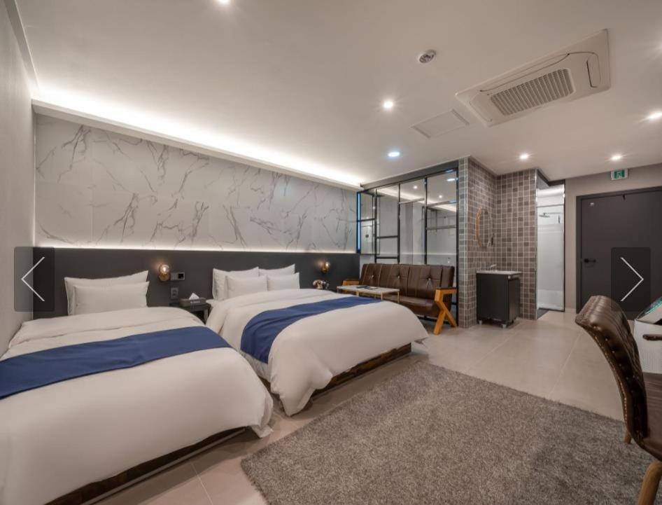 Dos camas en una habitación de hotel con avisor en Dongdaemun Saturn Hotel en Seúl