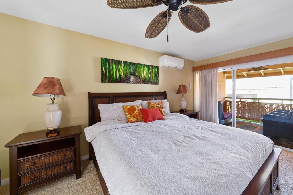 1 dormitorio con 1 cama y ventilador de techo en Gardenia Suite located across from beach in a boutique property en Kihei