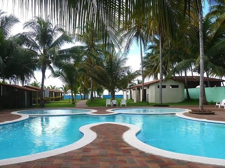 a swimming pool with palm trees in a resort at Casa del Sol, Barra de Santiago in Barra de Santiago