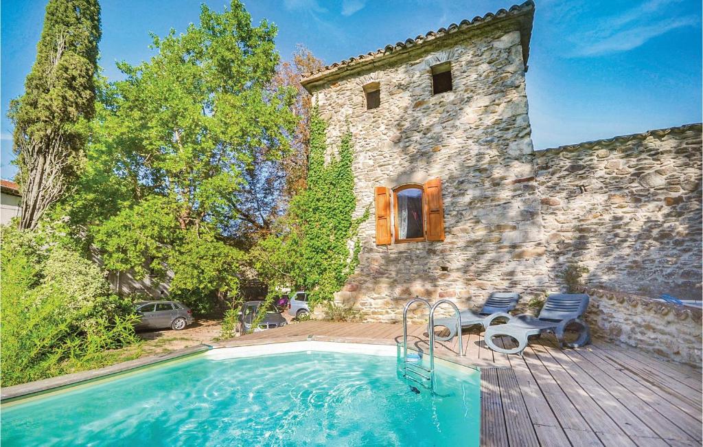 a swimming pool in front of a stone house at Lovely Apartment In Les Salles-du-gardon With Kitchen in Soustelle