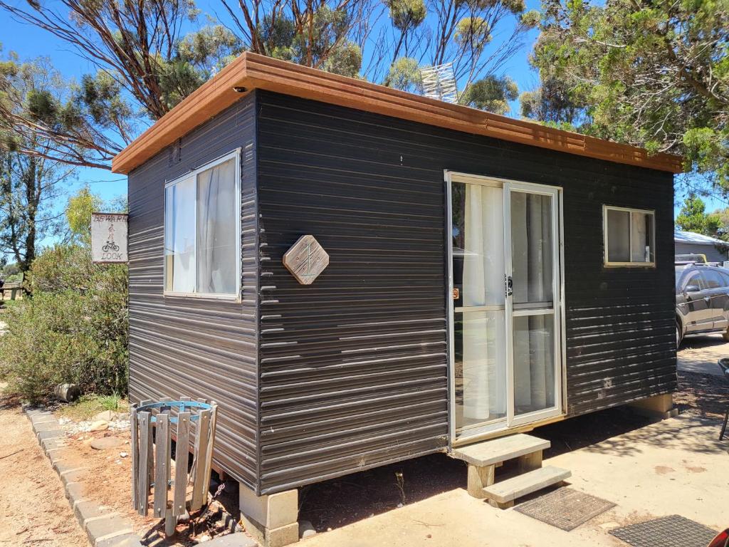 a black tiny house sitting in a parking lot at Kangaroo Lake C & C Park 