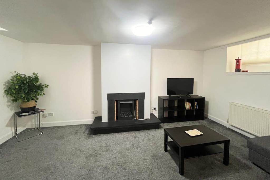 a living room with a fireplace and a table at Boyds Entry flat Old town in Edinburgh