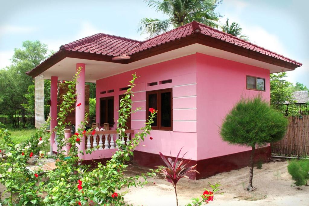 una casita rosa en un jardín en Kalinka Inn, en Gili Meno
