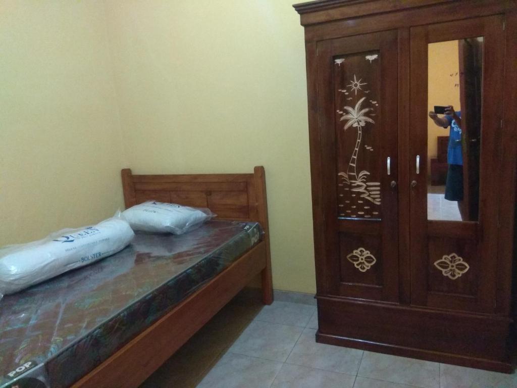 a bedroom with a bed and a wooden cabinet at Guest house TBE C9 in Tambakaji