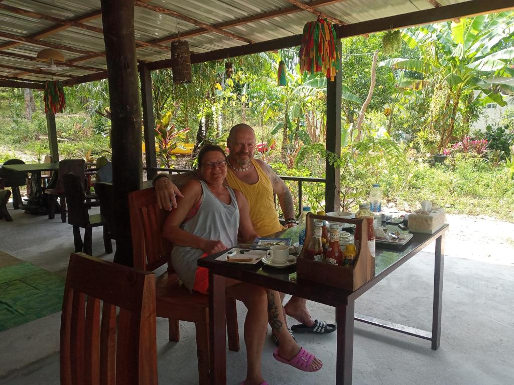 un hombre y una mujer sentados en una mesa en Bangkaew Camping place bangalow, en Krabi