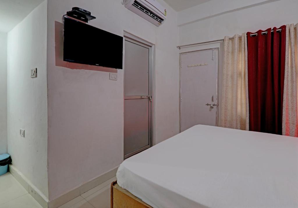 a bedroom with a bed and a flat screen tv at Hotel Surya Inn in Pura Raghunāth