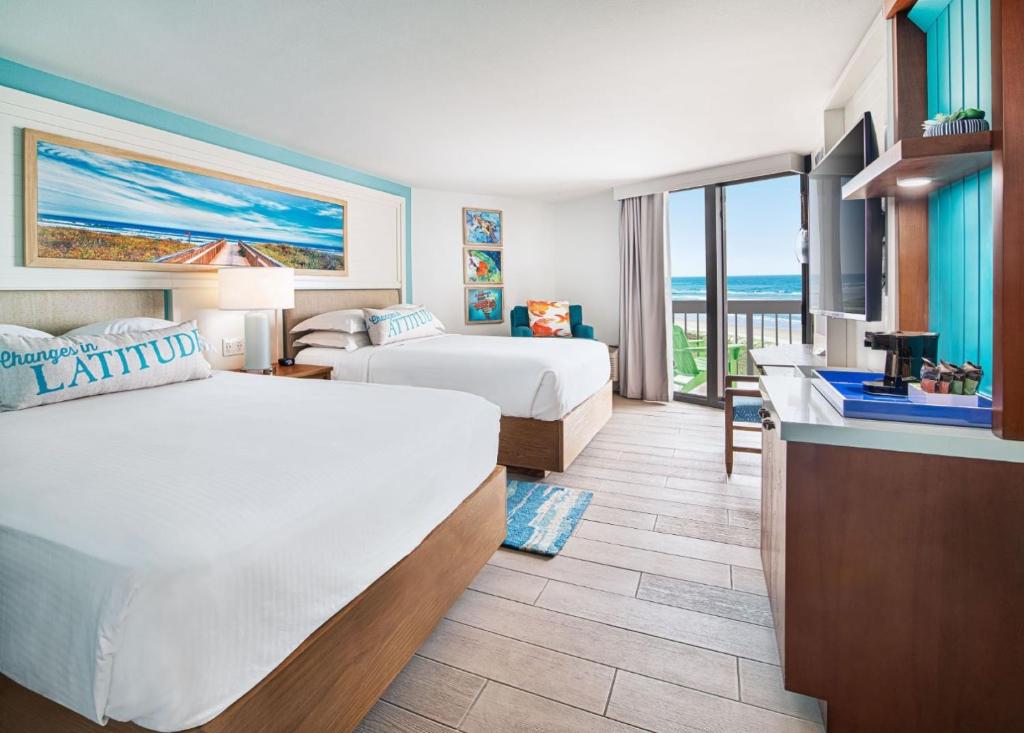 een hotelkamer met 2 bedden en een balkon bij Margaritaville Beach Resort South Padre Island in South Padre Island