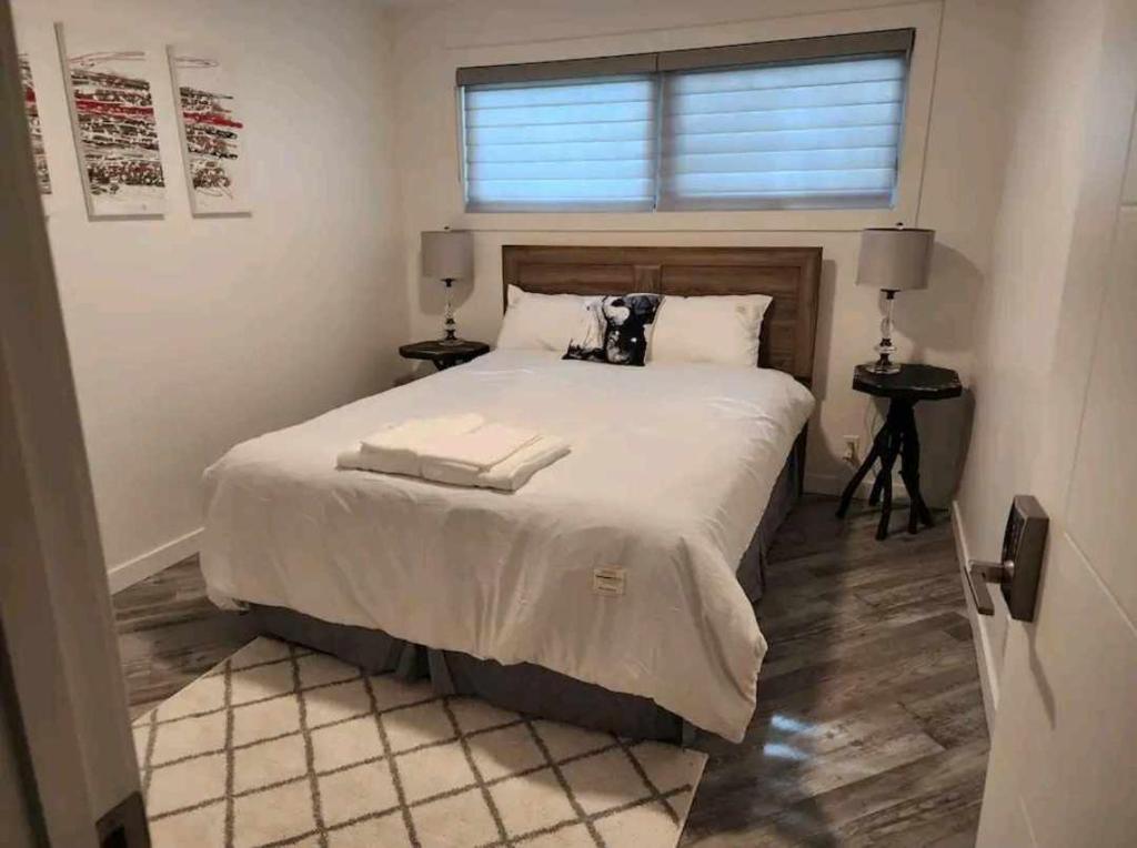 um quarto com uma cama com duas toalhas em Cozy em Regina