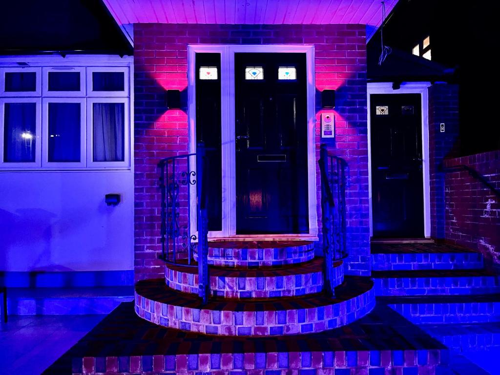 una casa con luces moradas en la puerta principal en Luxury 6 Bedroom House, all with En-suite bathroom - West London - Wembley Stadium, OVO Arena 5 km, en Greenford