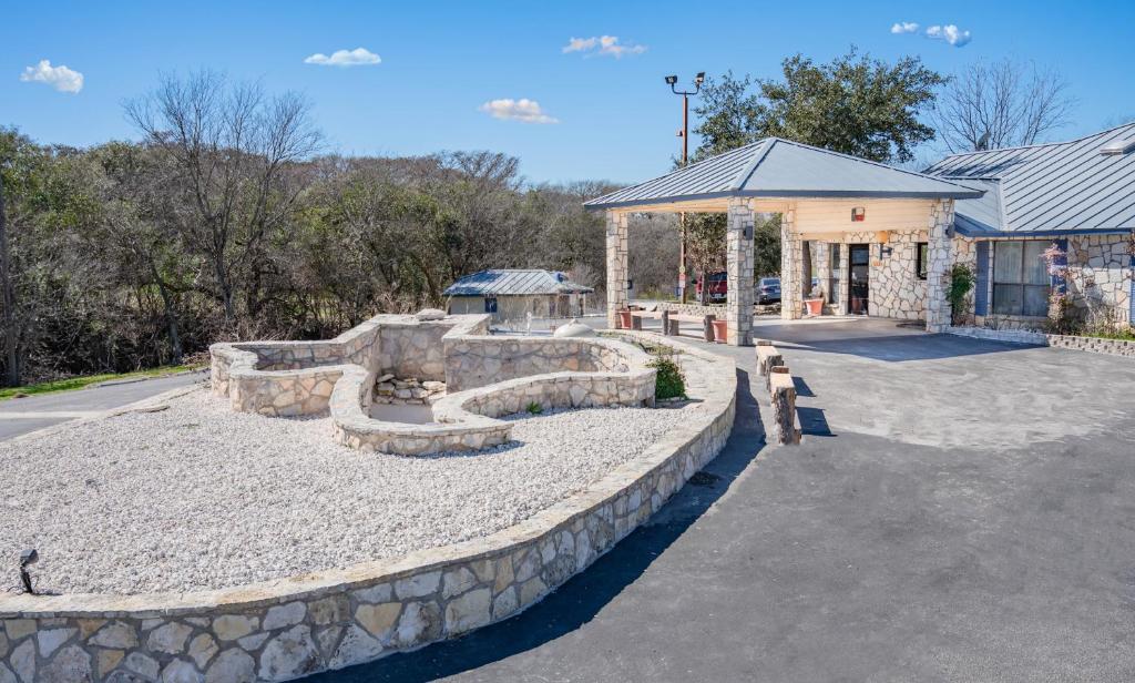a building with a stone wall and a seating area at RIVER OAK INN in Bandera