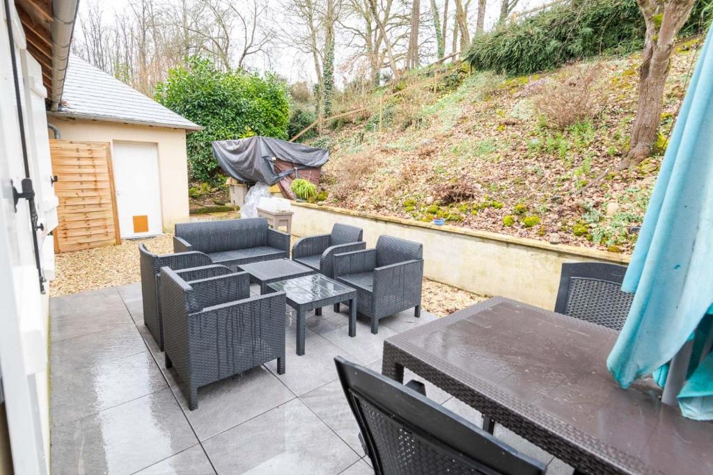 a patio with tables and chairs and a hill at Le Sapin Parasol - Maison pour 7 pers. in Lussault-sur-Loire