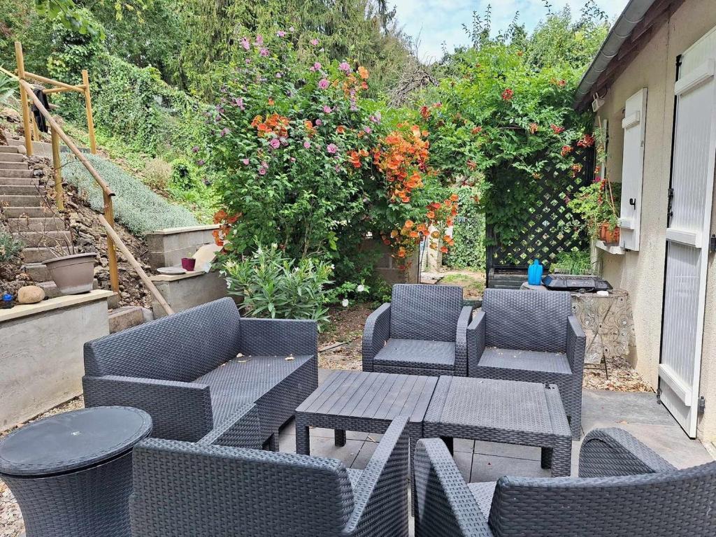 a patio with four chairs and a wooden table and a table and chairs at Le Sapin Parasol - Maison pour 7 pers. in Lussault-sur-Loire