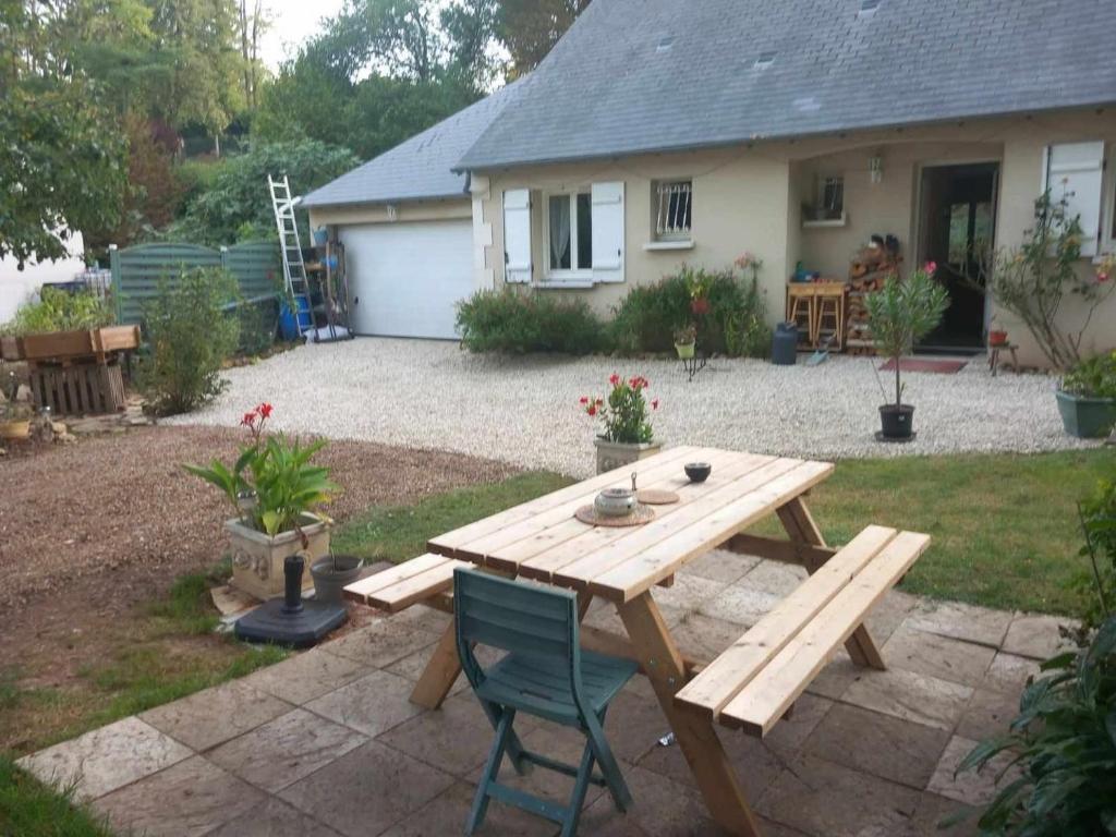 a wooden picnic table in the backyard of a house at Le Sapin Parasol - Maison pour 7 pers. in Lussault-sur-Loire