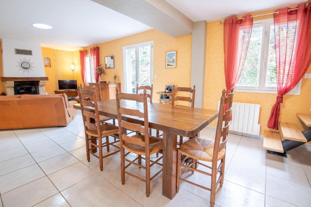 a dining room with a wooden table and chairs at Le Sapin Parasol - Maison pour 7 pers. in Lussault-sur-Loire