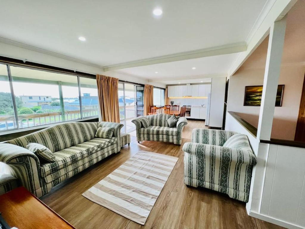 a living room with couches and a large window at Just A Glimpse in Robe