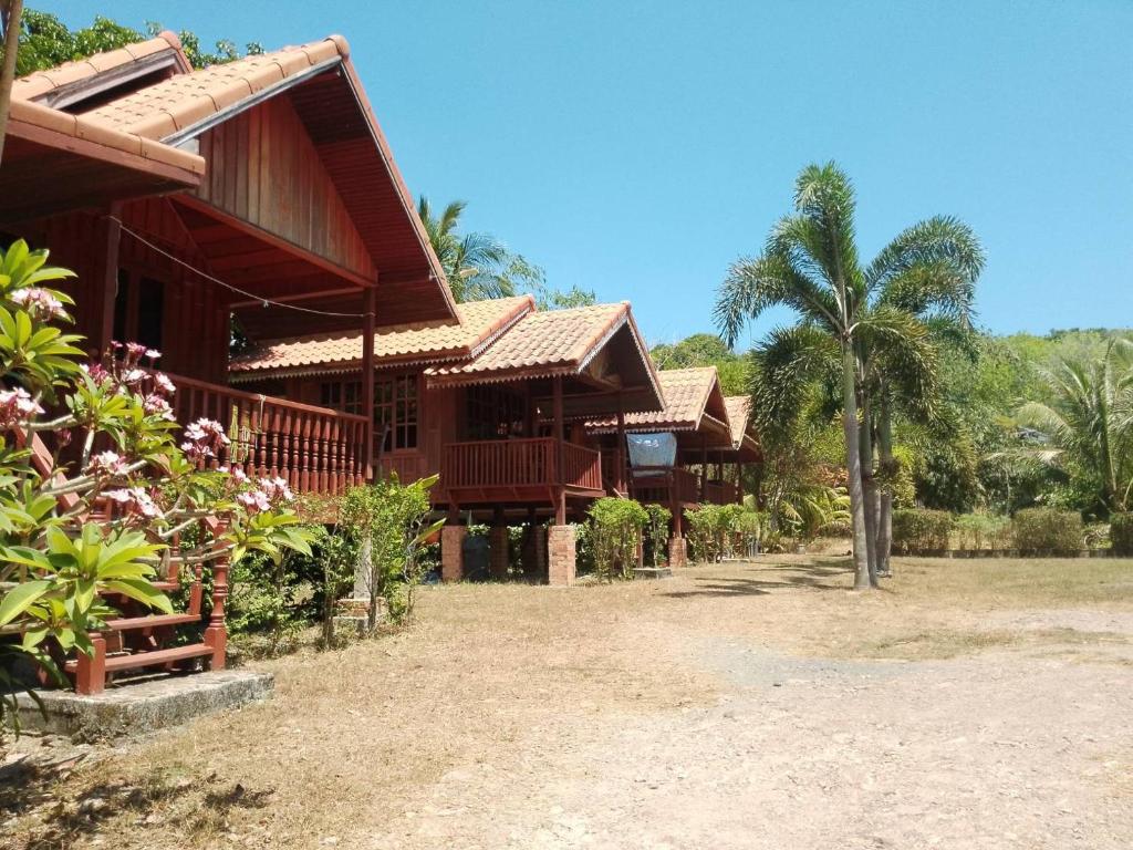 een rij huizen met palmbomen op de achtergrond bij Lanta Yoky bangalow in Phra Ae beach