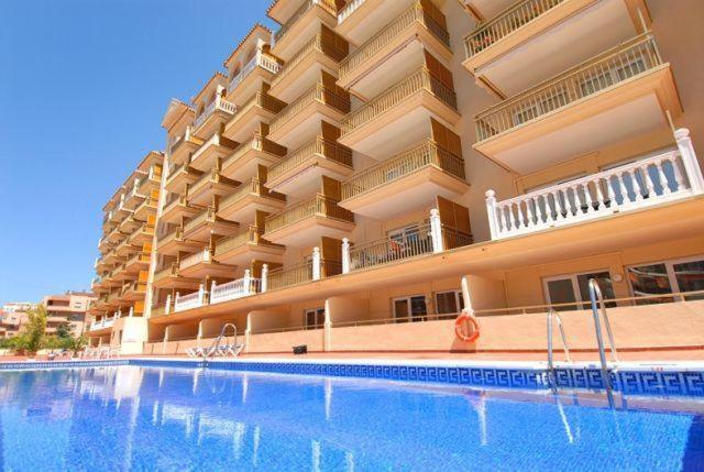 a hotel with a swimming pool in front of a building at Apartamentos Turísticos Yamasol in Fuengirola