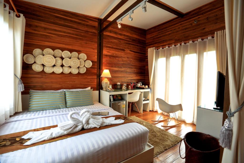 ein Schlafzimmer mit einem Bett mit einer Holzwand in der Unterkunft The Cottage Aonang in Ao Nang Beach