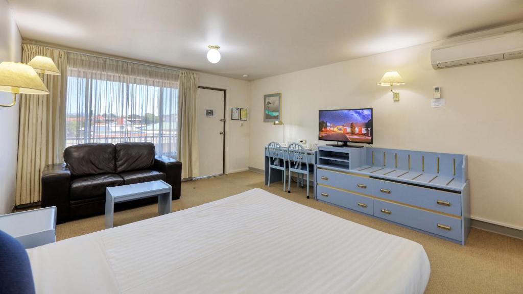 a hotel room with a bed and a living room at Sunrise Devonport in Devonport