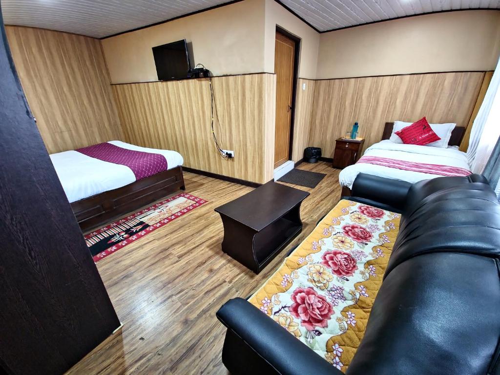 a hotel room with a couch and a bed at Veronica Alpina Mountain View Home in Darjeeling