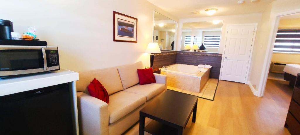 salon z kanapą i kuchenką mikrofalową w obiekcie Riviera Inn And Suites 1000 Islands w mieście Gananoque
