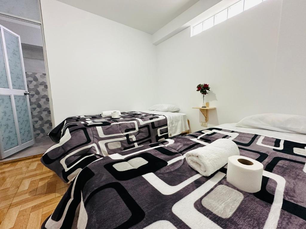 a black and white bed in a white room at Yerupaja Mountain Hostel in Huaraz