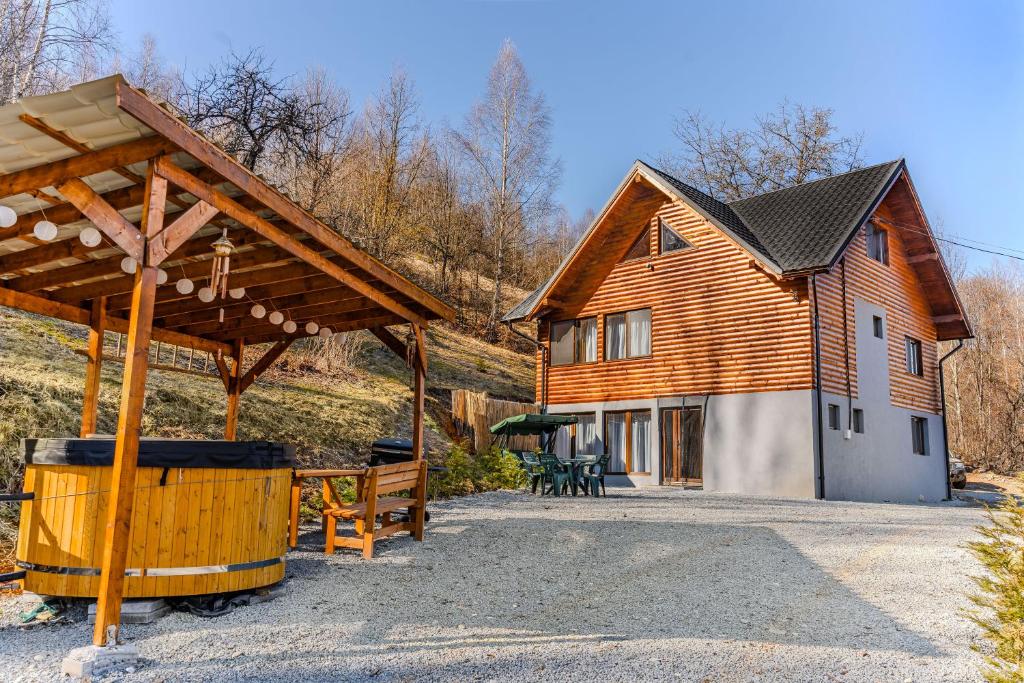 uma grande casa de madeira com um pavilhão em frente em Montain Wild Chalet with Wooden Hot Tub 