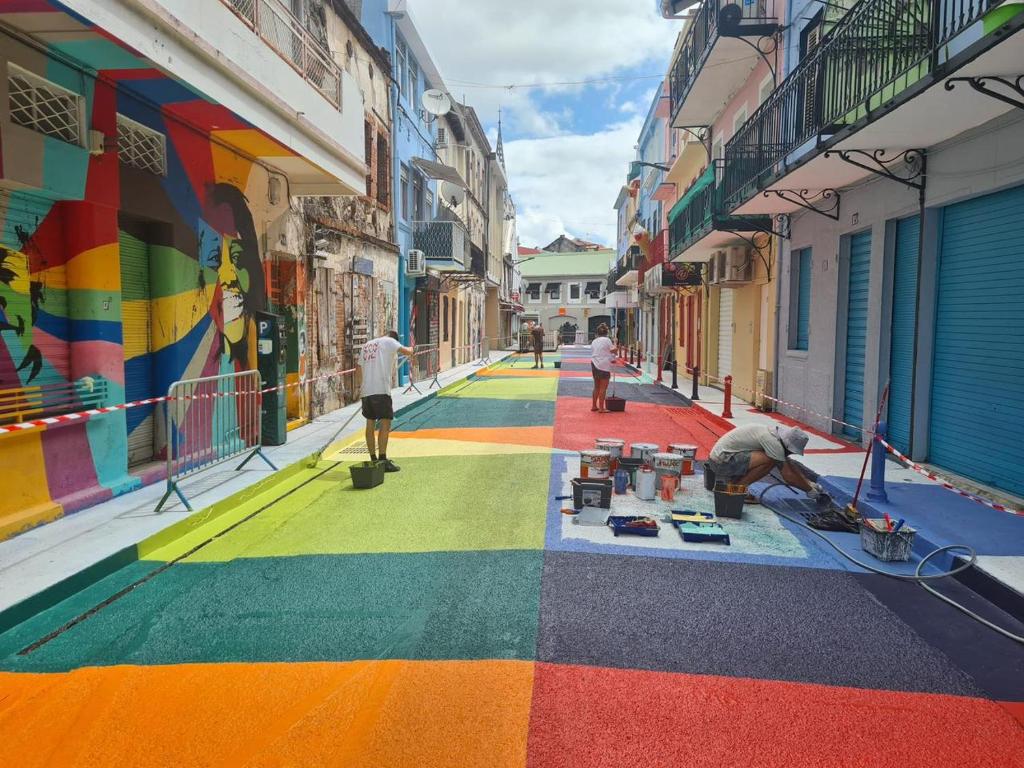 a group of people painting a mural on a street at SWEET PARADISE STUDIO à 10 mn du centre en voiture in Fort-de-France