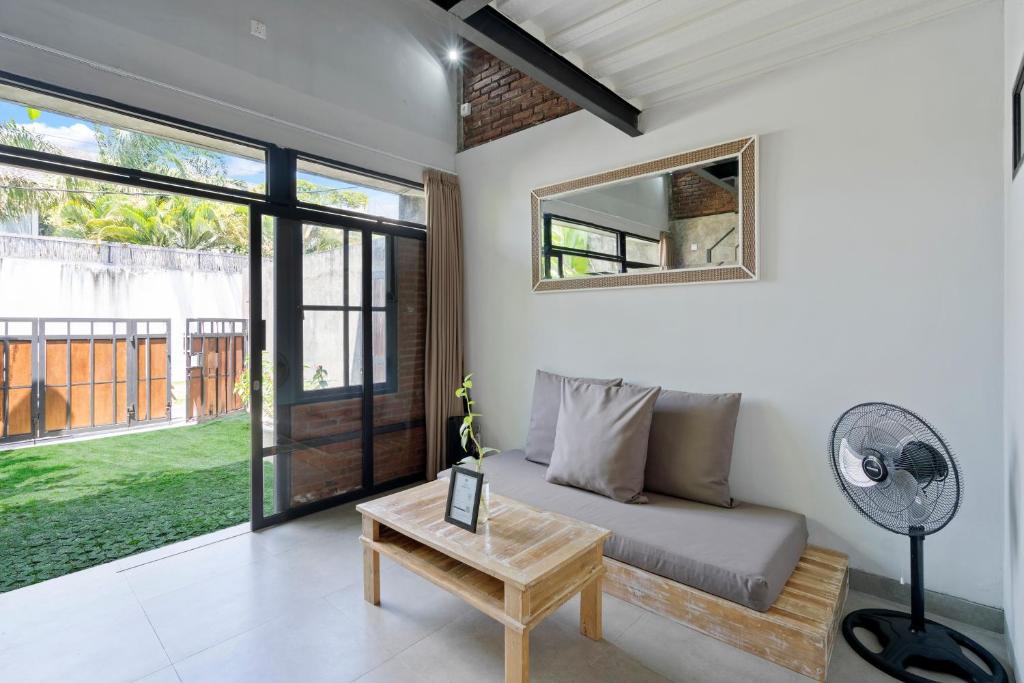 a living room with a couch and a fan at Ambara U6 Loft by Hombali in Canggu