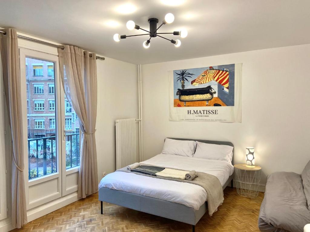 a bedroom with a bed with a ceiling fan and a window at Paris: agréable chambre d’un grand artiste in Paris