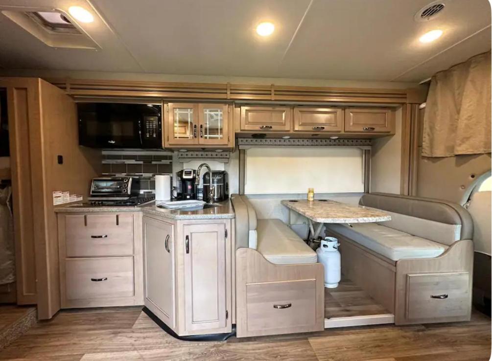 uma cozinha com autocaravana, armários brancos e um balcão. em Private Cozy R/V , for your enjoyment em Tamiami