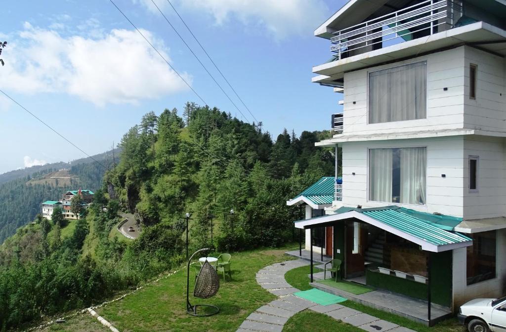 a house with a view of a mountain at Humble Holiday Inn Kufri Simla in Shimla