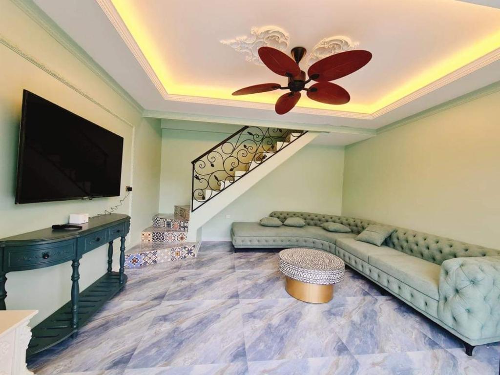 un soggiorno con divano e ventilatore a soffitto di Larita Đồi Cỏ Mơ a Hòa Bình