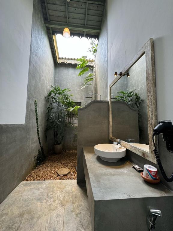 a bathroom with a sink and a mirror at Aurora in Unawatuna