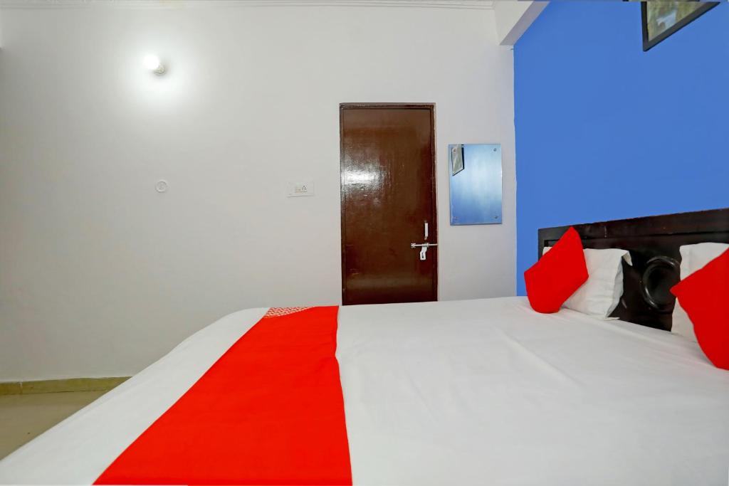 a bedroom with a bed with red pillows and a door at OYO Flagship Hotel Drip Inn in Lucknow