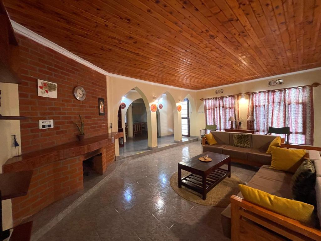 sala de estar con sofá y chimenea en Toiwo Residence Arusha en Arusha