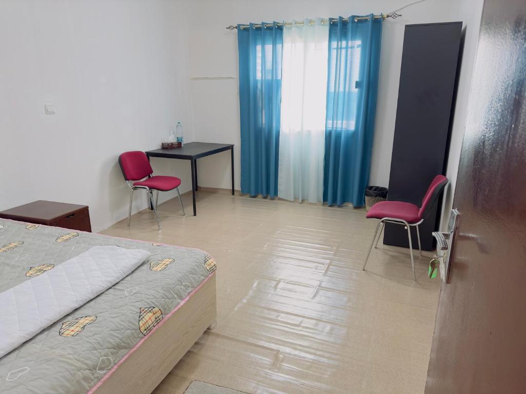 1 dormitorio con 1 cama, 2 sillas y mesa en Big bedroom in apartment sharing washroom, en Sharjah
