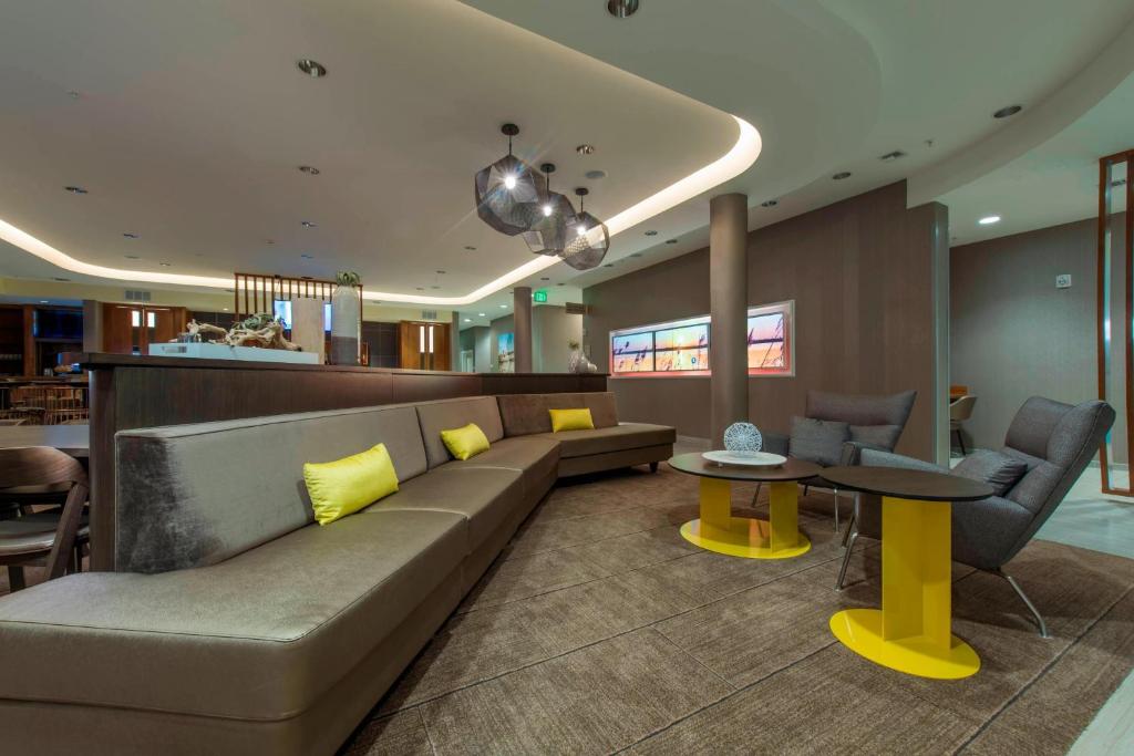 a lobby with a couch and two tables and chairs at SpringHill Suites by Marriott Gallup in Gallup