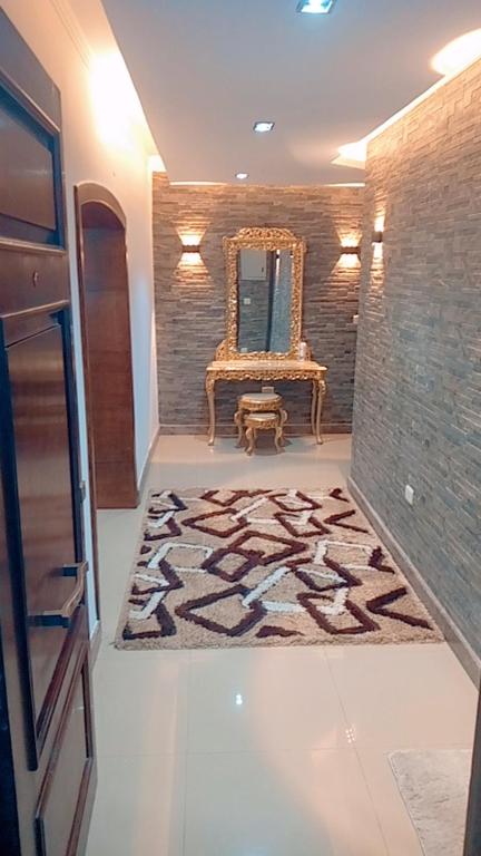 una stanza con specchio, sedia e tappeto di المهمدسين a Il Cairo