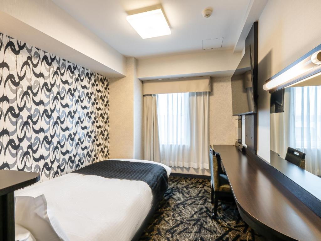 Postel nebo postele na pokoji v ubytování APA Hotel Niigata Tsubamesanjo Ekimae