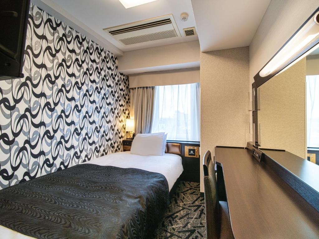 Postel nebo postele na pokoji v ubytování APA Hotel Niigata Tsubamesanjo Ekimae