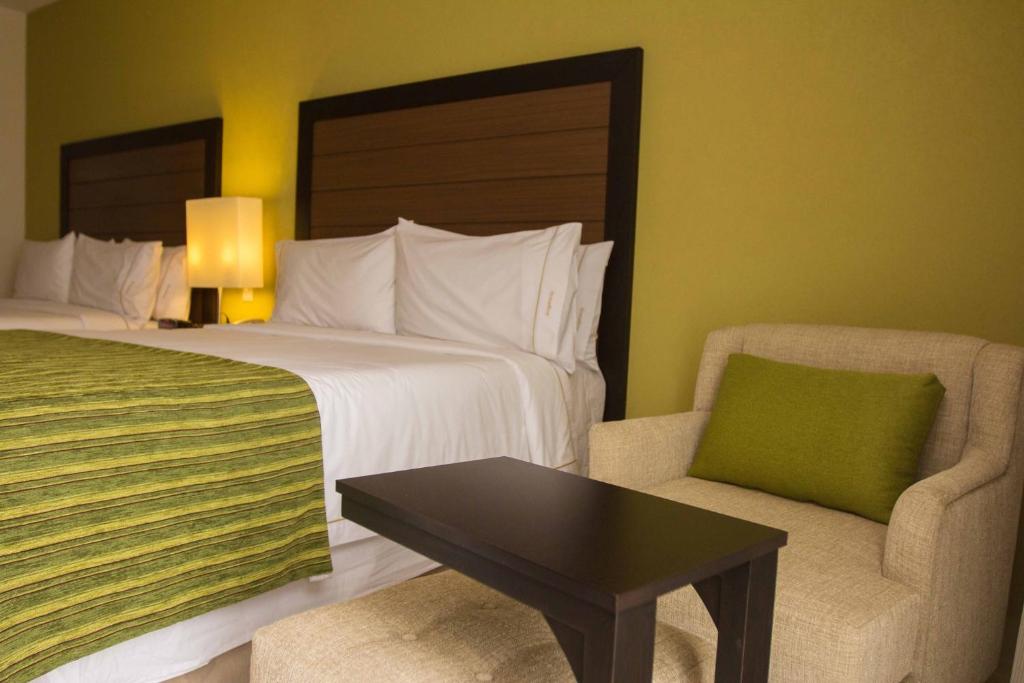 een hotelkamer met een bed en een stoel bij Holiday Inn Express Xalapa, an IHG Hotel in Xalapa