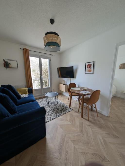 un salon avec un canapé bleu et une table dans l'établissement Appartement T2 Petite Jade, à Luchon